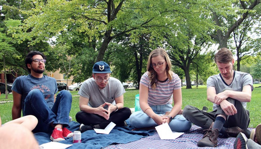 Le pasteur Tim Kim (au centre), des membres et invités de l&#039;Eglise Root &amp; Branch Church se rassemblent pour un service d&#039;Eglise à table, le 25 août 2019, au Palmer Square Park à Chicago. / RNS